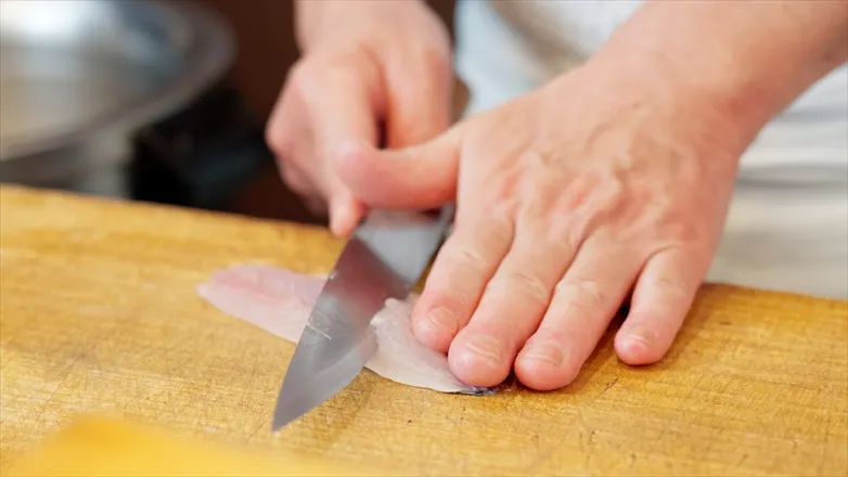 魚をおろす料理人の手元